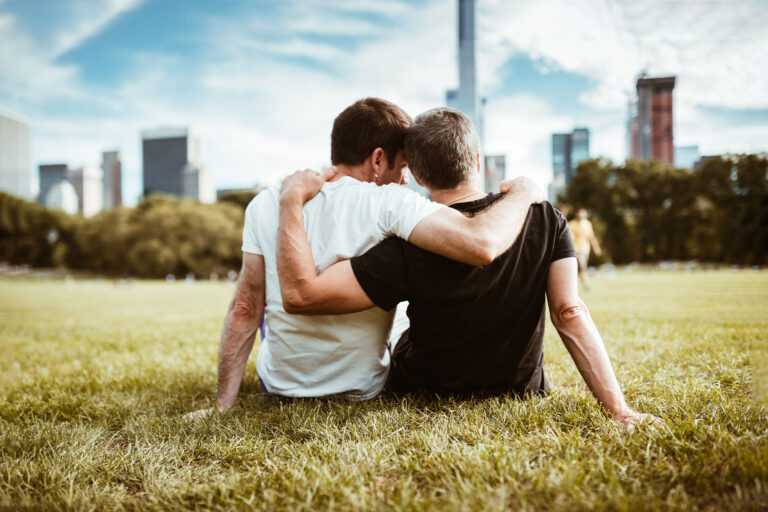 Gay couple sitting outside together (Getty Images/franckreporter)