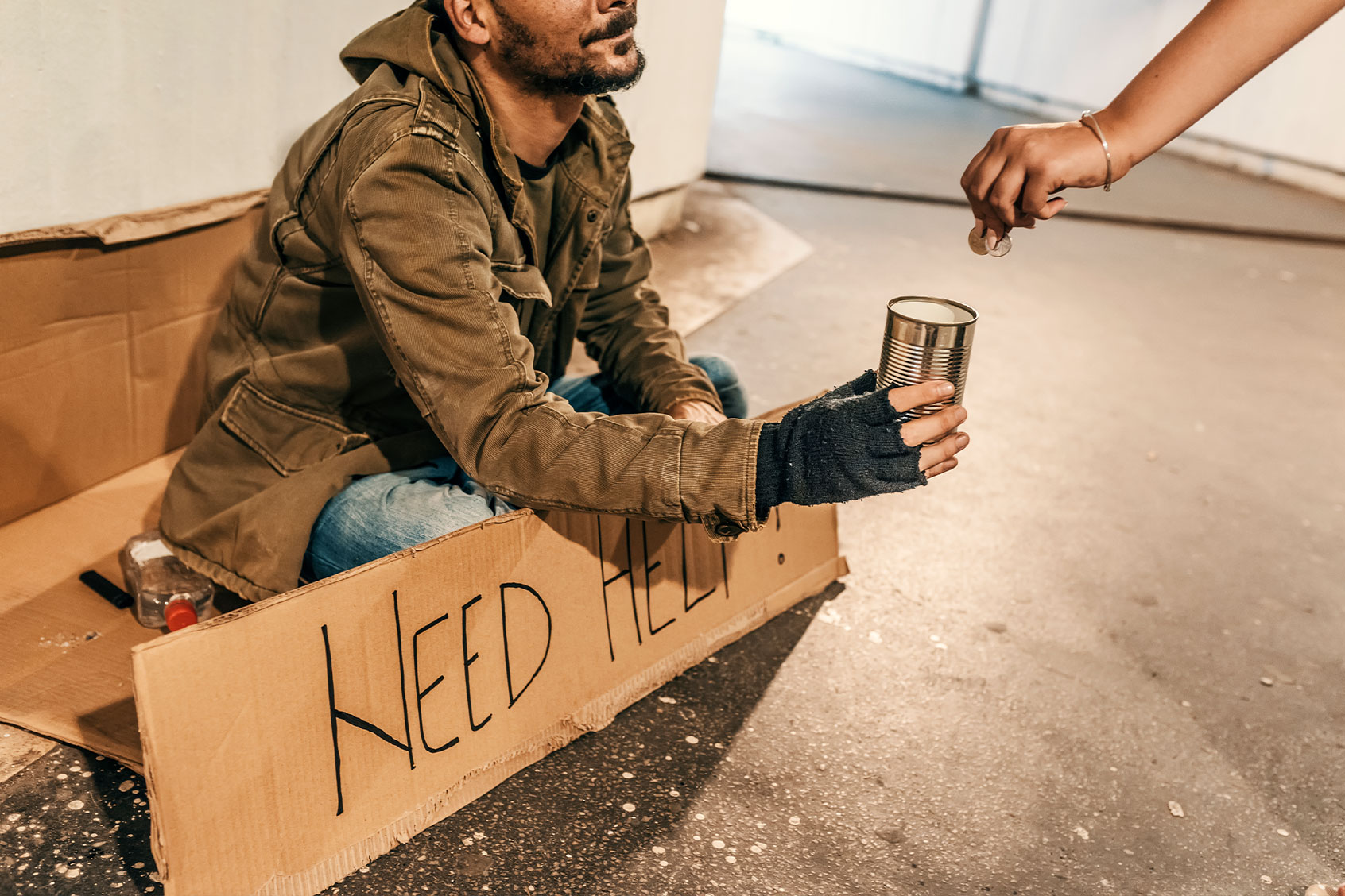 Photo of a person giving money to a beggar (Getty Images/ljubaphoto)