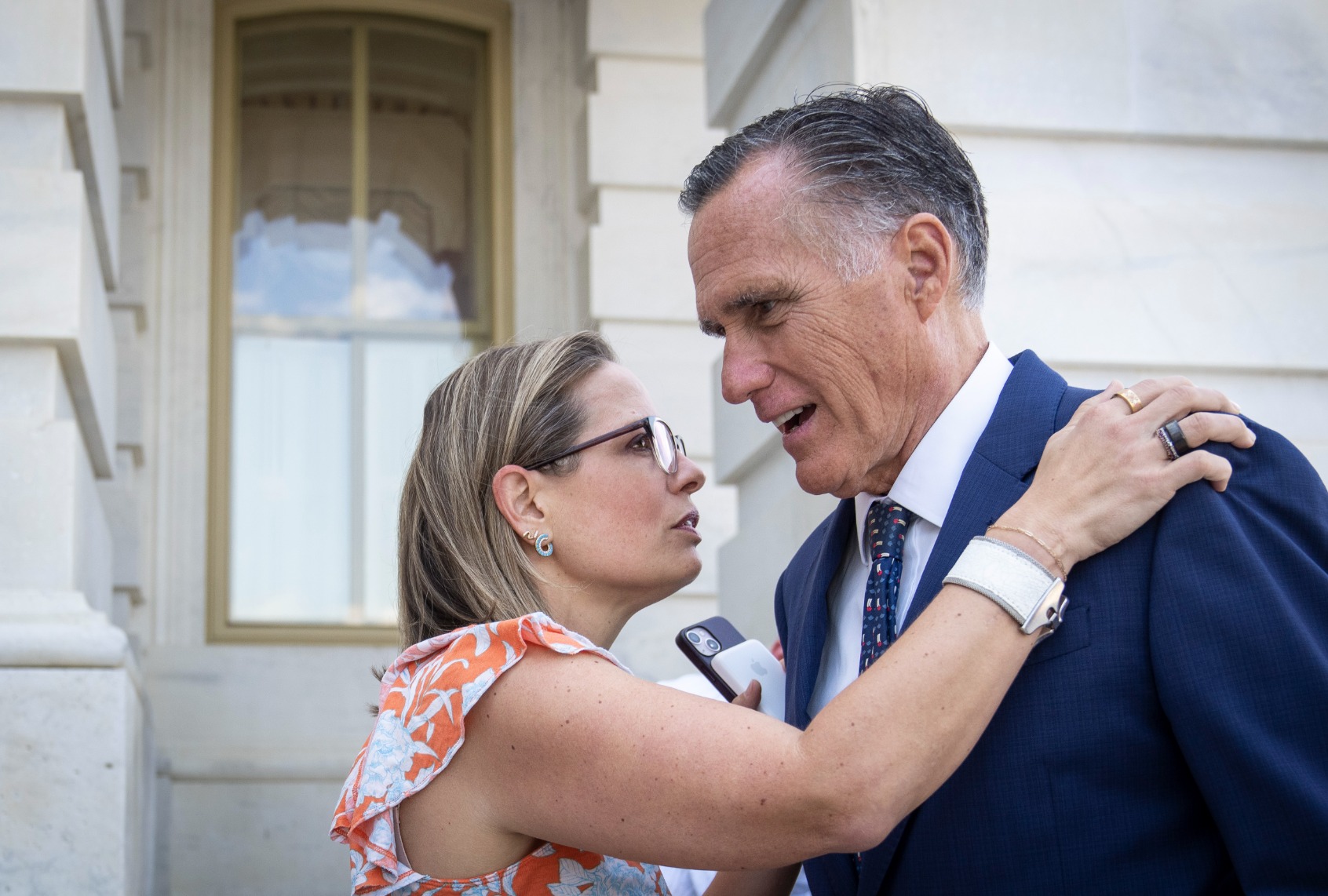 Sen. Kyrsten Sinema (D-AZ) talks with Sen. Mitt Romney (R-UT) outside the U.S. Capitol August 4, 2022 in Washington, DC. (Drew Angerer/Getty Images)