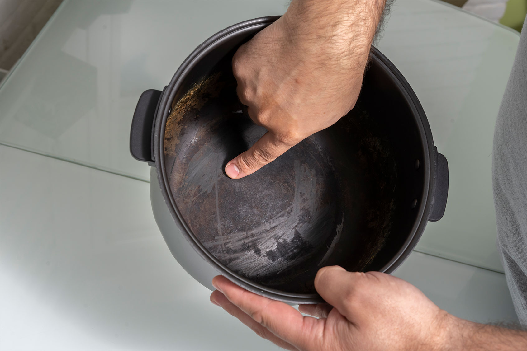 A man holding a non-stick pan with a damaged coating (Getty Images/Elena Gurova)