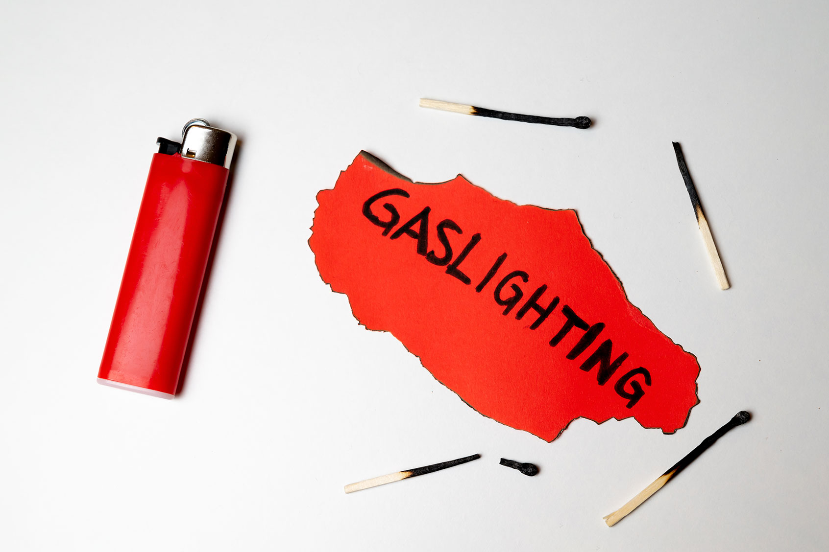 Red card, with the word "gaslighting" written in black, and burnt matches around it (Getty Images/Daniele Mezzadri)