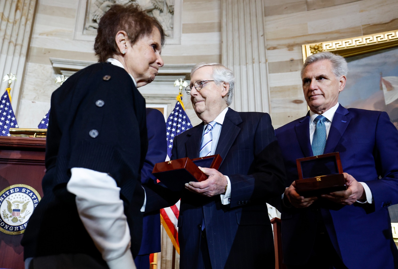 Senate Minority Leader Mitch McConnell (R-KY) (C) holds out his hand for a handshake with Gladys Sicknick (L), the mother of Capitol Police officer Brian Sicknick who died after the events of January 6, during a Congressional Gold Medal Ceremony for U.S. Capitol Police and D.C. Metropolitan Police officers in the Rotunda of the U.S. Capitol Building on December 6, 2022 in Washington, DC. (Anna Moneymaker/Getty Images)