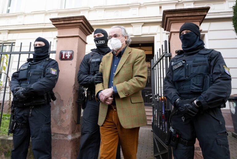 In a raid against so-called "Reichsbürger" masked police officers, after searching a house Heinrich XIII Prince Reuss (2nd from right) lead to a police vehicle. The Federal Prosecutor's Office had several people from the so-called Reichsbürger scene arrested in the course of a raid on Wednesday morning. (Boris Roessler/picture alliance via Getty Images)