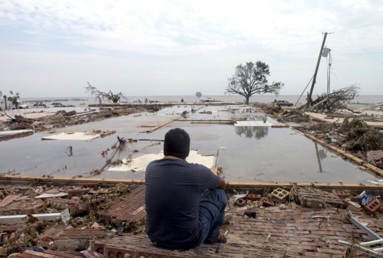 A man looks over the concrete slab that used to be his apartment after Hurricane Katrina, August 30, 2005. (Barry Williams/Getty Images)