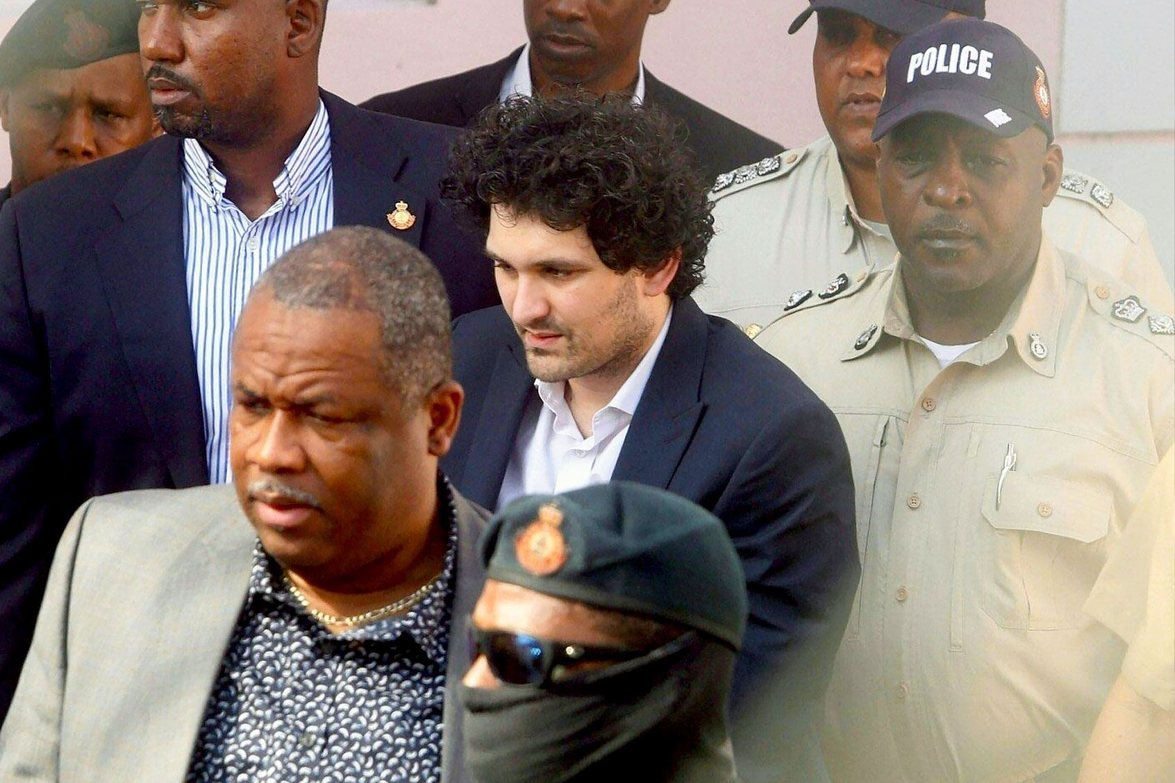 FTX founder Sam Bankman-Fried (C) is led away handcuffed by officers of the Royal Bahamas Police Force at the Nassau, Bahamas, courthouse on December 19, 2022. (KRIS INGRAHAM/AFP via Getty Images)