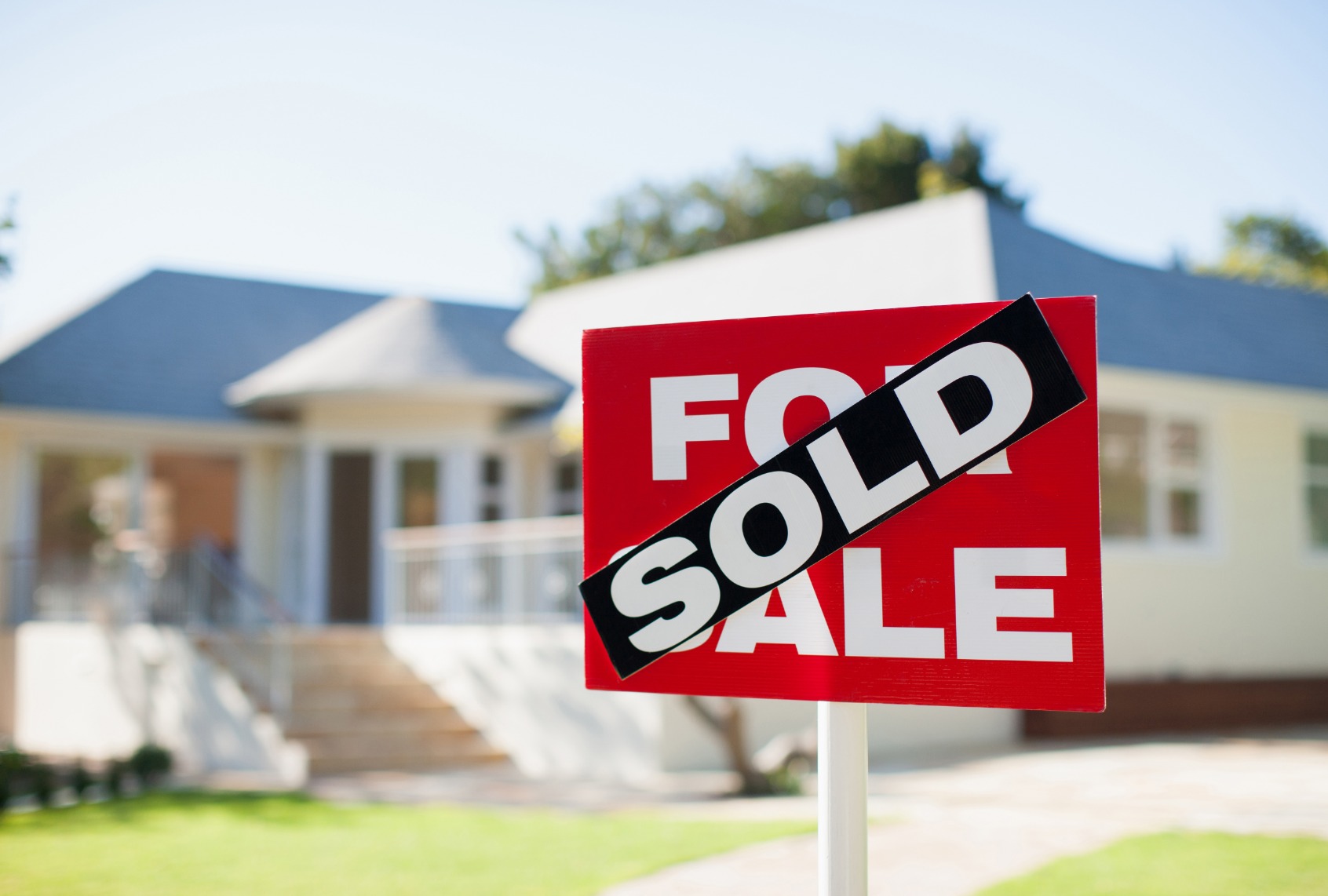 For sale sign in yard of house. (Martin Barraud/Getty Images)