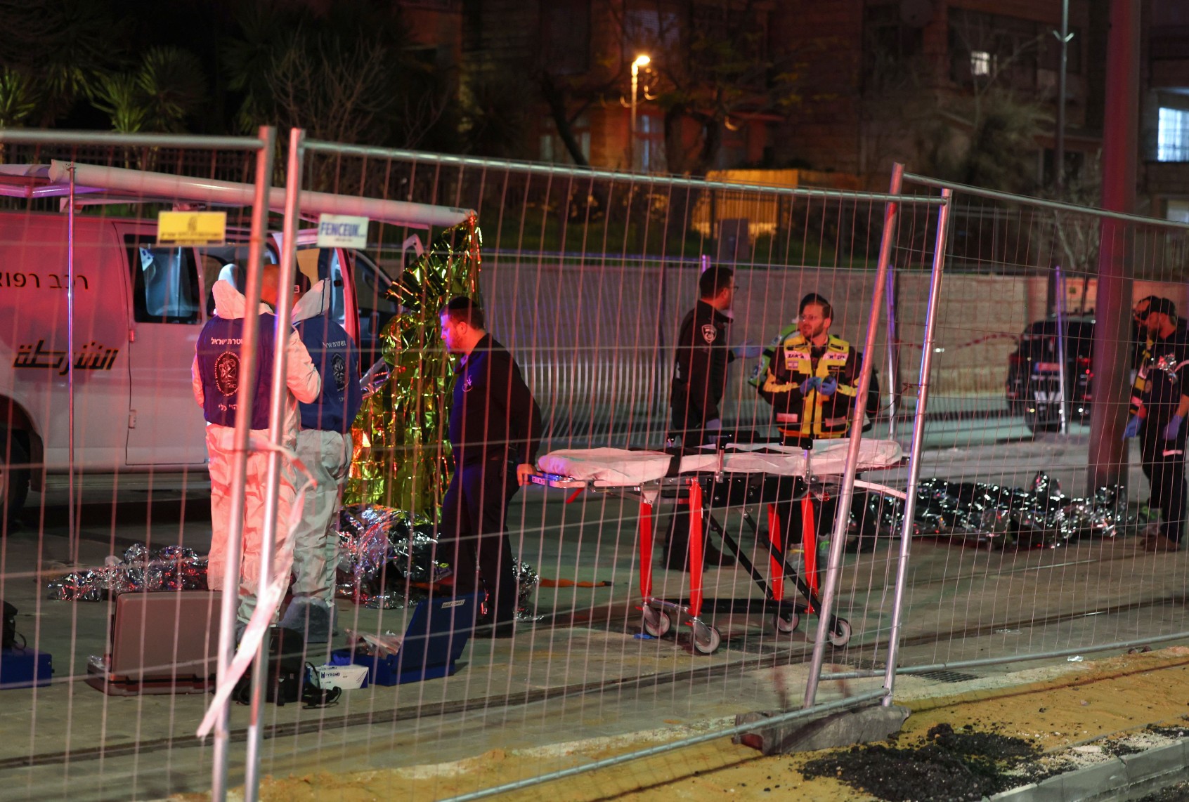 Israeli emergency service personnel transport casualties at the site of a reported attack in a settler neighborhood of Israeli-annexed east Jerusalem, on January 27, 2023. (AHMAD GHARABLI/AFP via Getty Images)