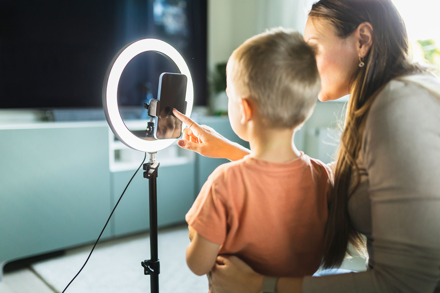 Mother live streaming with son on smartphone with ring light at home (Getty Images/Westend61)
