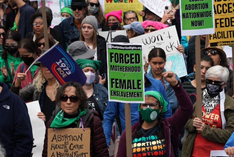 Demonstrators hold signs during a rally to defend abortion access and codify Roe v Wade into law, in Foley Square in New York City on October 8, 2022. (BRYAN R. SMITH/AFP via Getty Images)