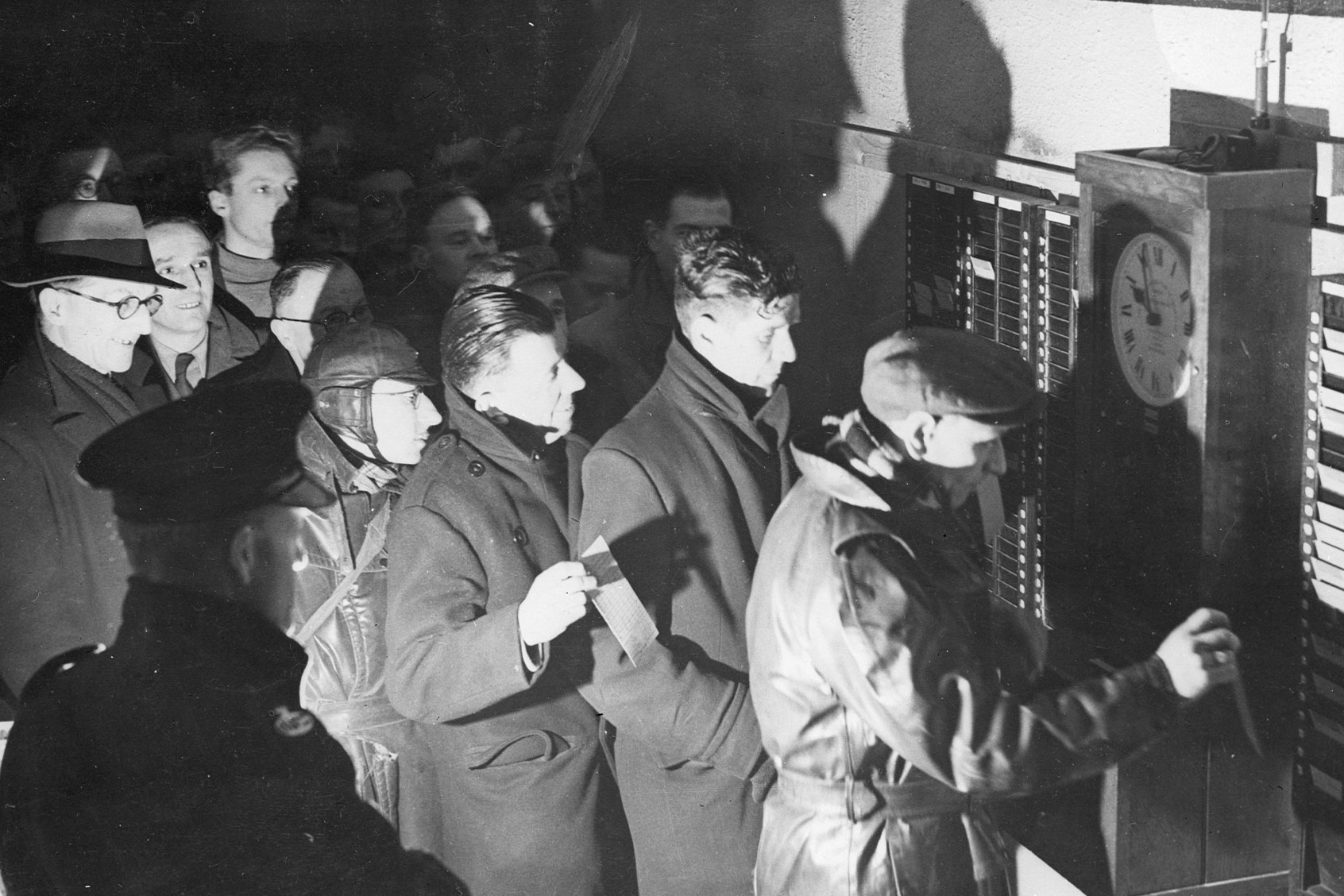 Workers clocking in at 10 pm, at the start of the night shift at the Philips electrical works in Mitcham, London, March 04, 1947. (Keystone/Getty Images)