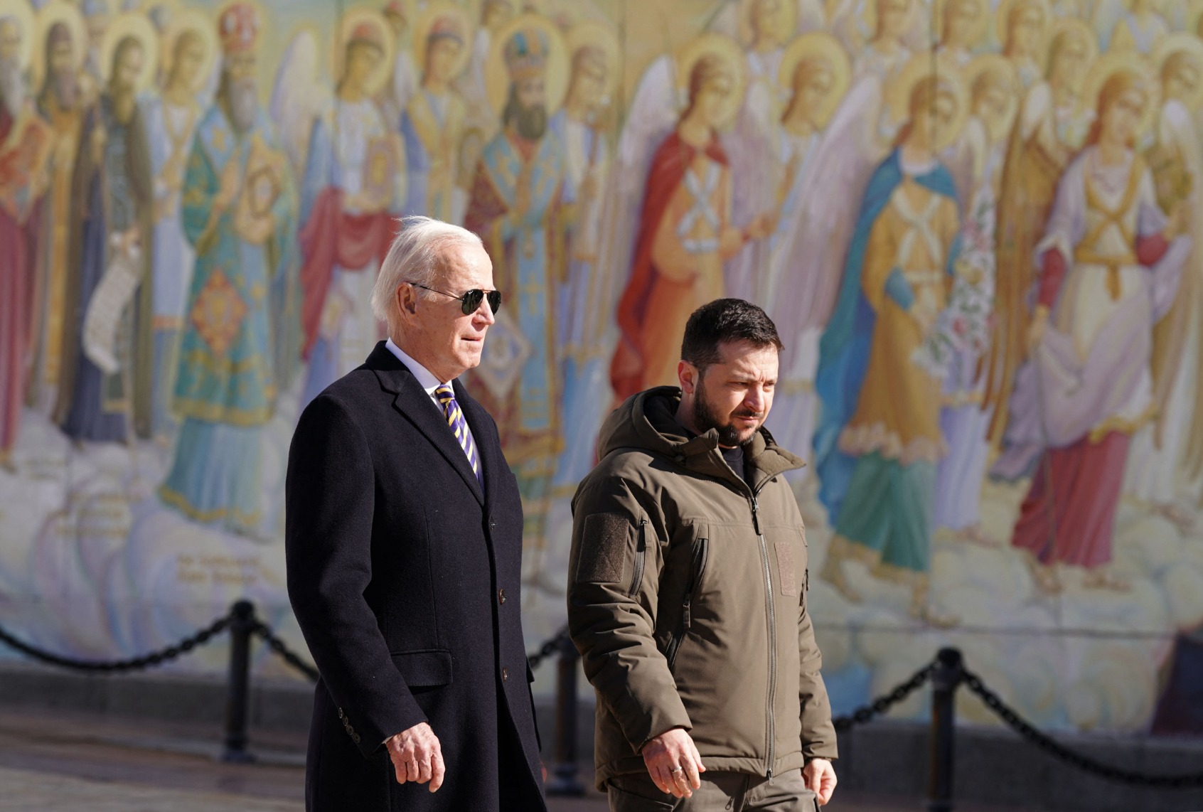 President Joe Biden walks next to Ukrainian President Volodymyr Zelenskyy past a religious mural at the St. Michaels Golden-Domed Cathedral, as he arrives for a visit in Kyiv on February 20, 2023. (DIMITAR DILKOFF/AFP via Getty Images)