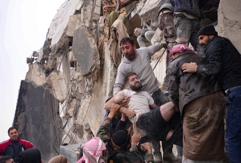 Residents retrieve an injured man from the rubble of a collapsed building following an earthquake in the town of Jandaris, in the countryside of Syria's northwestern city of Afrin in the rebel-held part of Aleppo province, on February 6, 2023. (RAMI AL SAYED/AFP via Getty Images)
