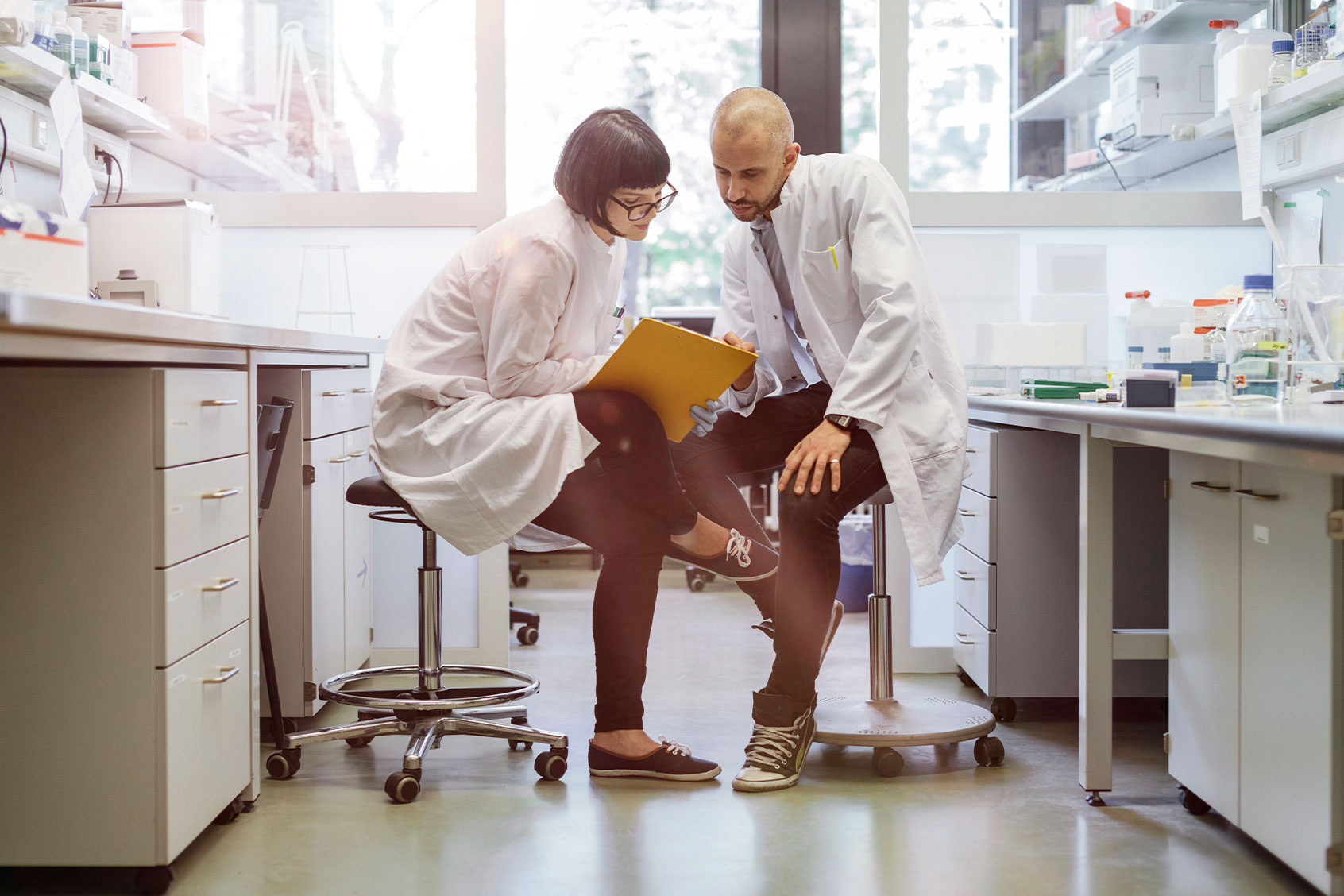 Two scientists sitting inside a laboratory discussing their research. (Getty Images/Hinterhaus Productions)