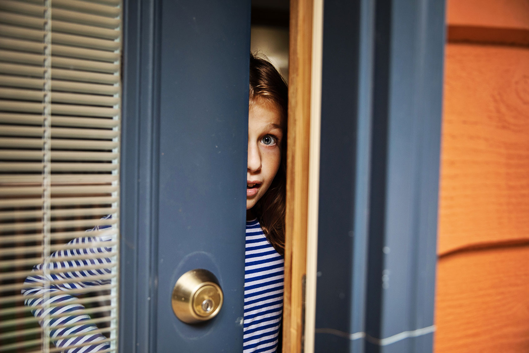 Young girl opening front door (Getty Images/vitapix)