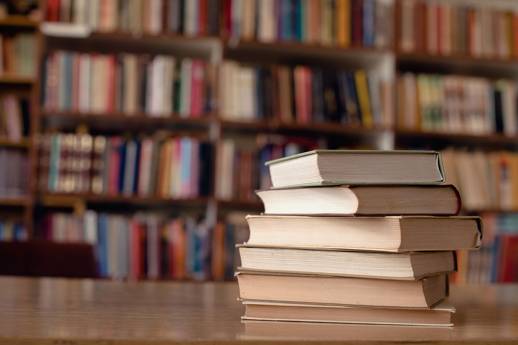 Books on a desk in the library (Getty Images/jovan_epn)