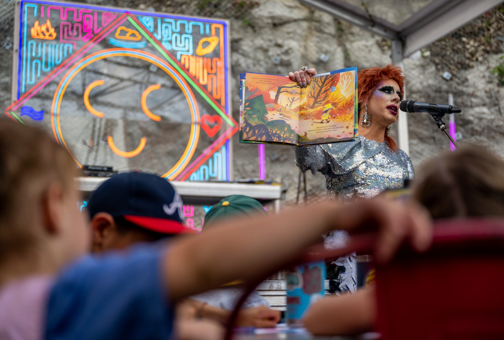 Drag Queen Ona Louise reads a book during a story time reading at the Cheer Up Charlies dive bar on March 11, 2023 in Austin, Texas. (Brandon Bell/Getty Images)