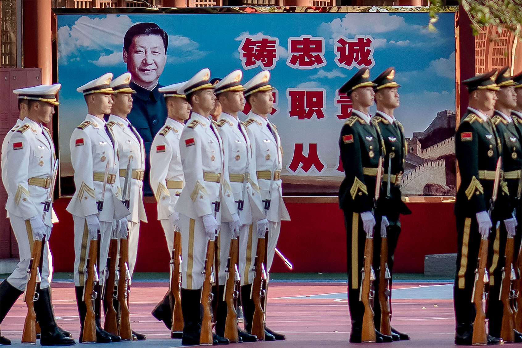 Military personnel stand in formation next to a portrait of China's President Xi Jinping (back) outside the Forbidden City in Beijing on October 22, 2020, on the eve of the 70th anniversary of Chinas entry into the 1950-53 Korean War. (NICOLAS ASFOURI/AFP via Getty Images)