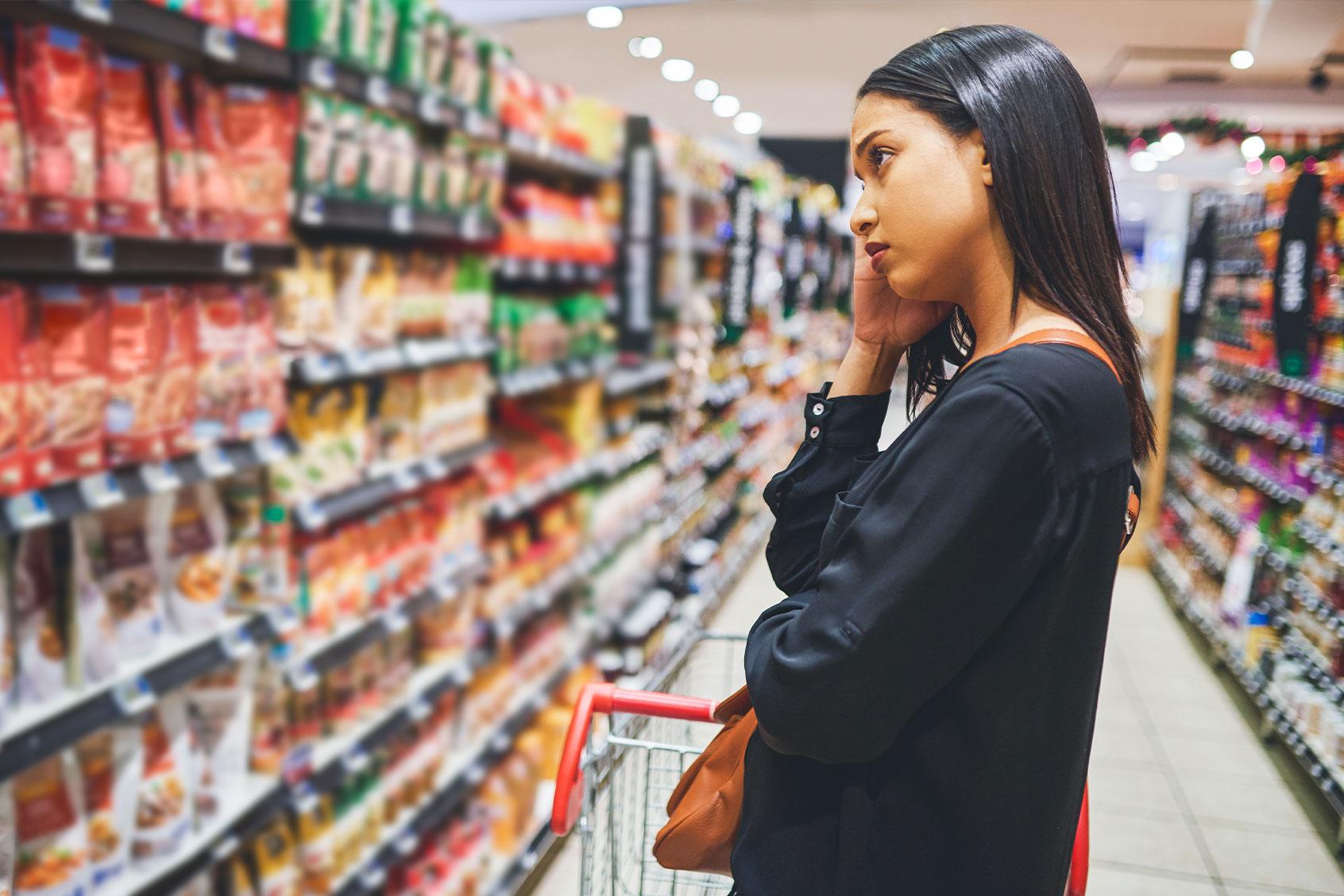 Woman shopping in a grocery store (Getty Images/Moyo Studio)