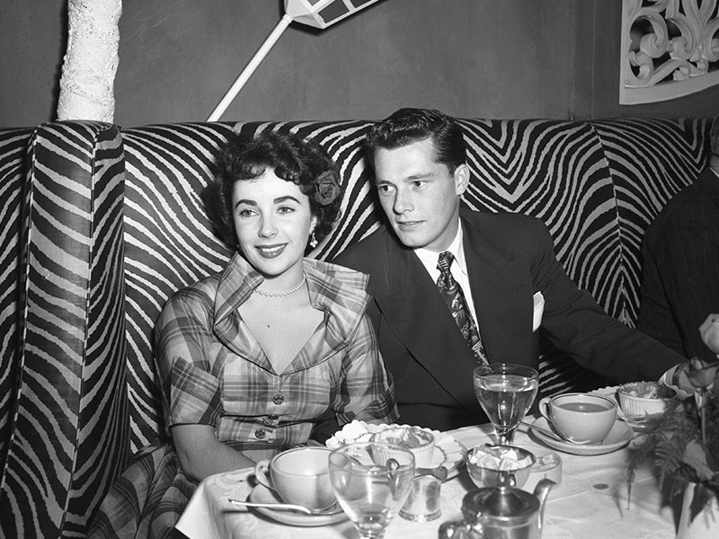 Elizabeth Taylor sits with Conrad Hilton Jr.