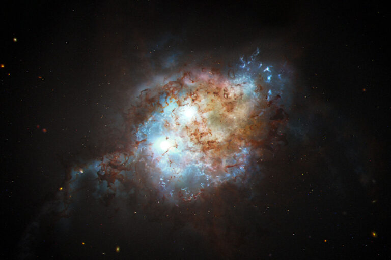 This artist's concept shows the brilliant glare of two quasars residing in the cores of two galaxies that are in the chaotic process of merging. (NASA, ESA, Joseph Olmsted (STScI))