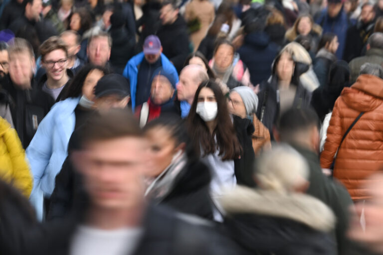 A woman wearing a mask walks in the crowd (Arne Dedert/picture alliance via Getty Images)