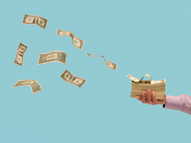 Money flying off stack of bills