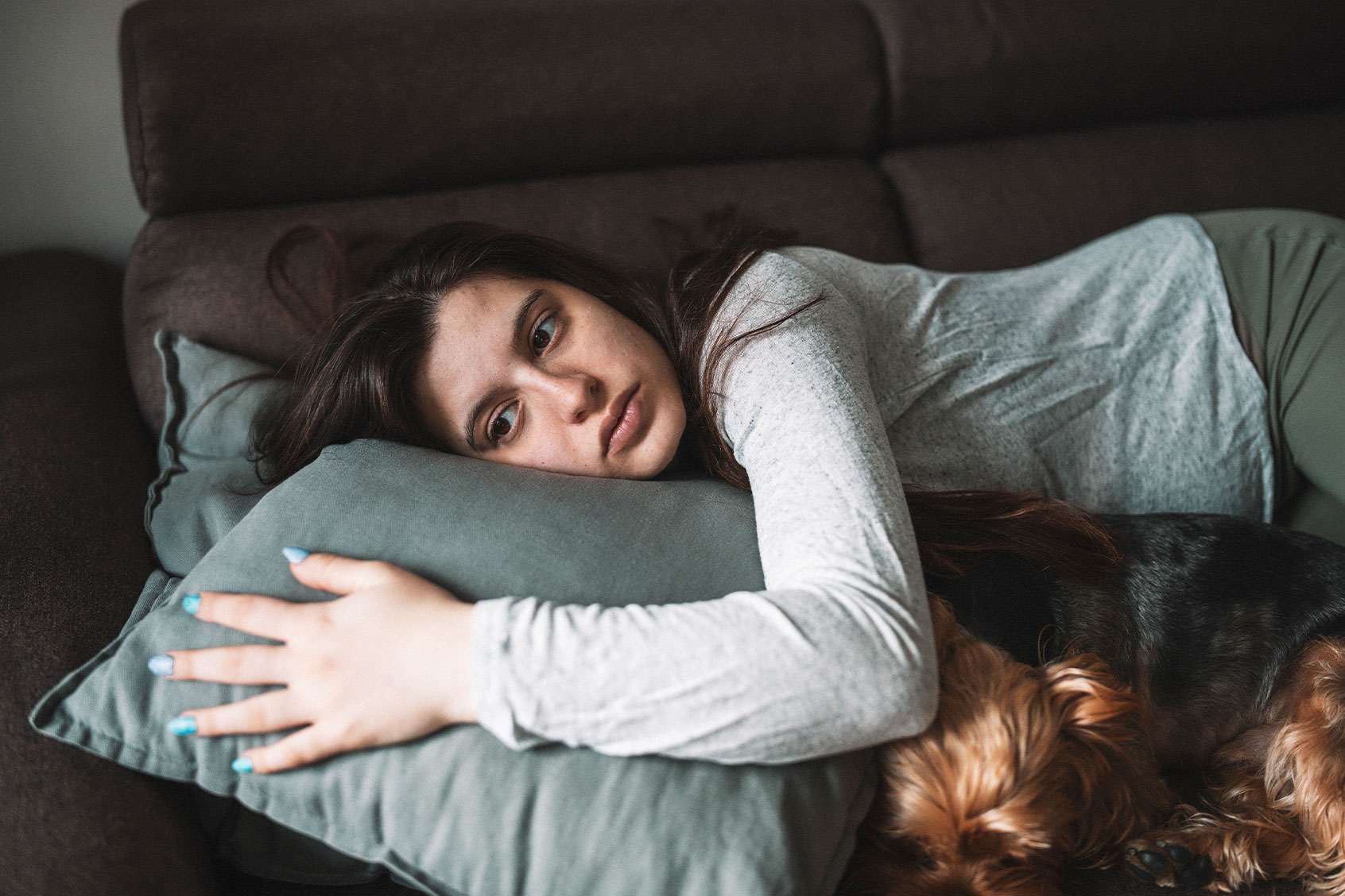 Sad woman on the couch (Getty Images/ArtistGNDphotography)