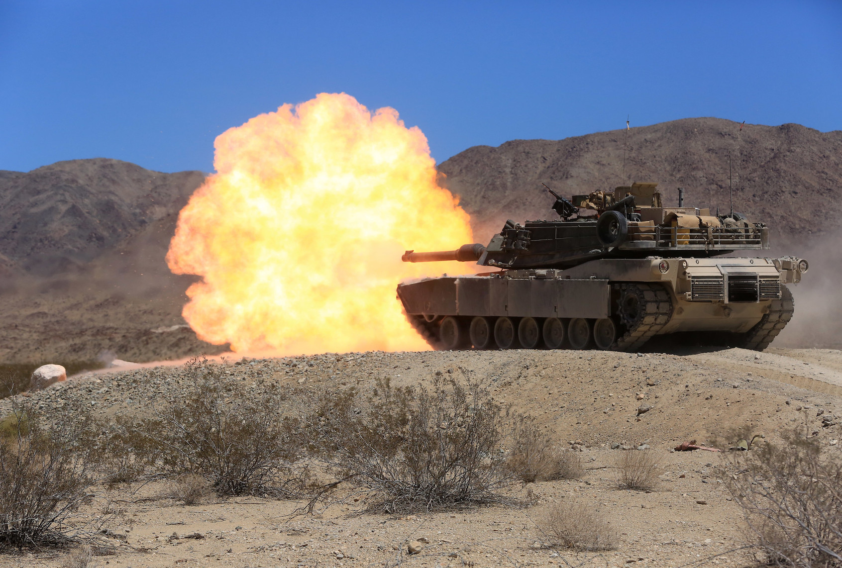 An M1A1 Abrams Main Battle Tank crew with Company A, 4th Tank Battalion, fires its 120 mm main gun during the company’s pre-qualification tank gunnery at Range 500, Aug. 4, 2015. The live-fire exercise tests tank crews on their ability to work together on target acquisition and accuracy. (U.S. Marine Corps Photo by Lance Cpl. Julio McGraw/Released)