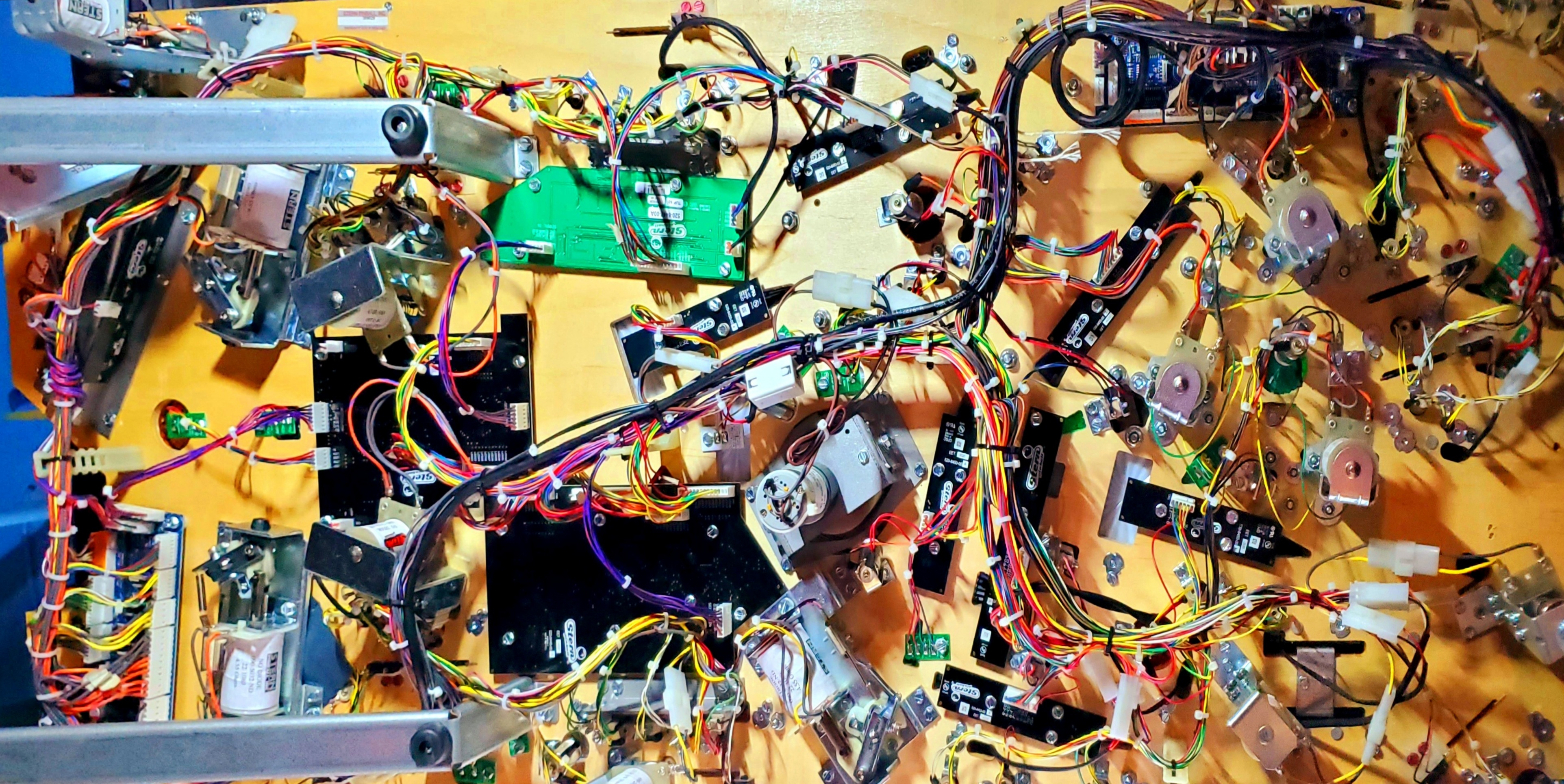The underside of a pinball playfield reveals the seeming chaos of its careful electrical structure.  