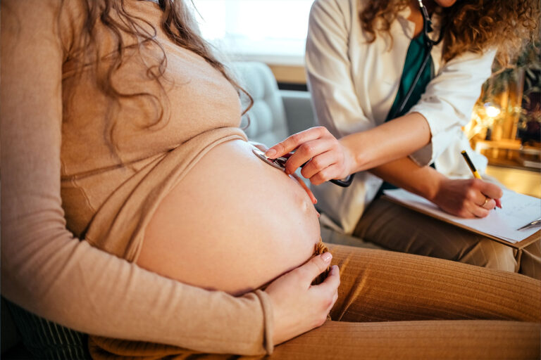 Doctor checking pregnant woman with stethoscope (Getty Images/StefaNikolic)