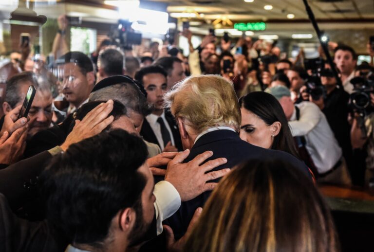 Former President Donald Trump prays with supporters as he visits the Versailles restaurant in the Little Havana neighborhood after being arraigned at the Wilkie D. Ferguson Jr. United States Federal Courthouse on June 13, 2023 in Miami, Florida. (Stephanie Keith/Getty Images)