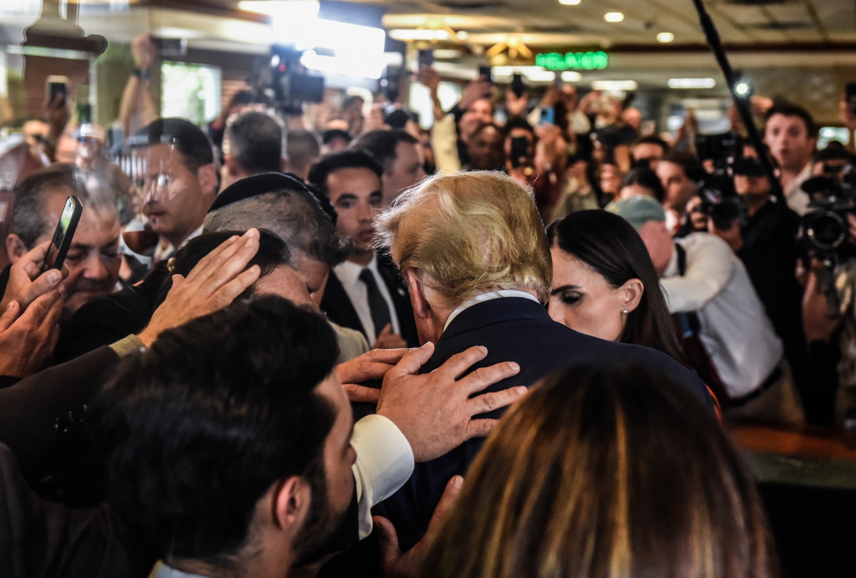 Former President Donald Trump prays with supporters as he visits the Versailles restaurant in the Little Havana neighborhood after being arraigned at the Wilkie D. Ferguson Jr. United States Federal Courthouse on June 13, 2023 in Miami, Florida. (Stephanie Keith/Getty Images)