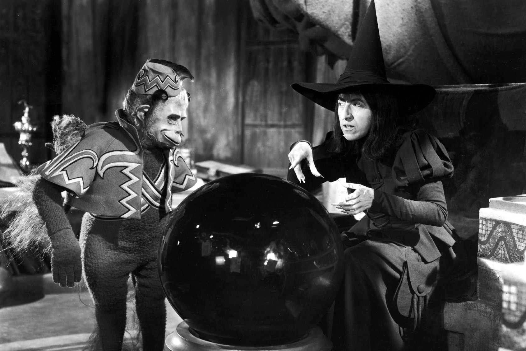 Margaret Hamilton and a winged monkey look into a crystal ball in a still from the film, "The Wizard of Oz," directed by Victor Fleming, 1939. (MGM Studios/Courtesy of Getty Images)