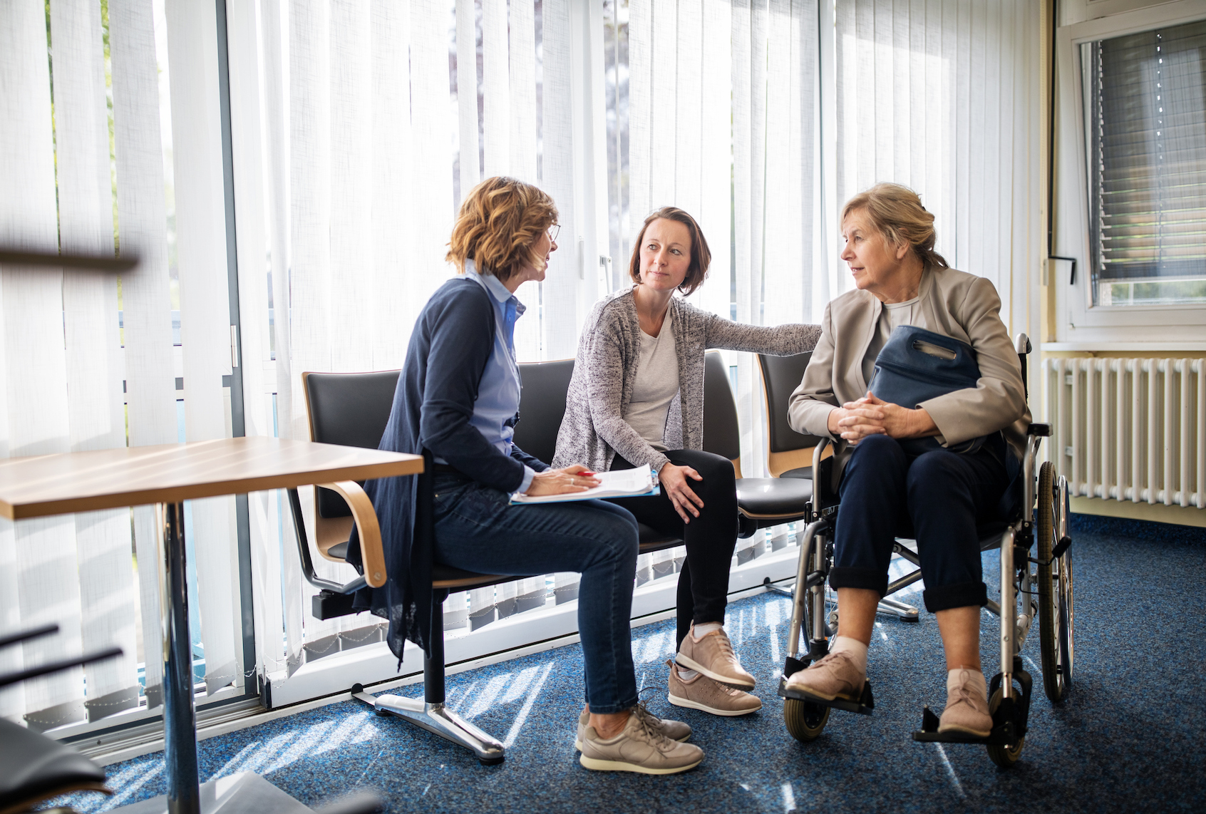 Therapist discussing with women in waiting room. (Luis Alvarez via Getty Images)
