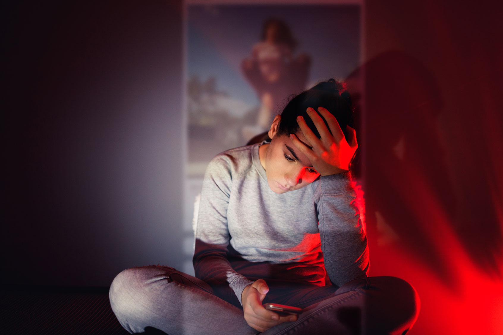 A 13-year-old girl is using her smartphone in the dark room (Getty Images)