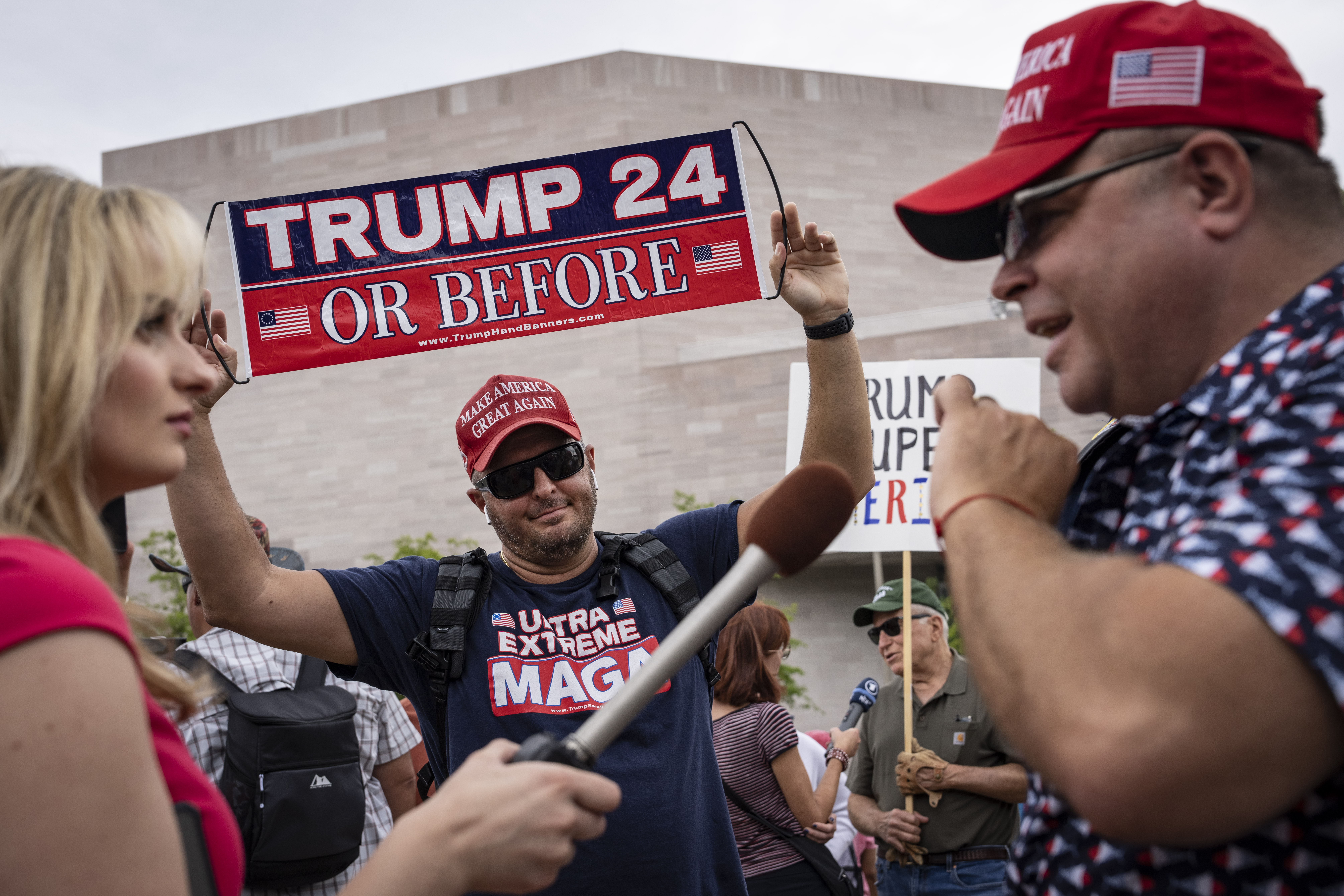 A reporter interviews Donald Trump supporters outside the E. Barrett Prettyman U.S. Courthouse in Washington, D.C., on Aug. 3. (Drew Angerer/Getty Images)