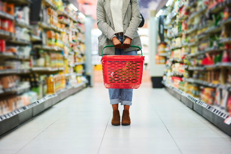 Supermarket aisle, woman legs and basket for shopping in grocery store (Getty Images/Adene Sanchez)