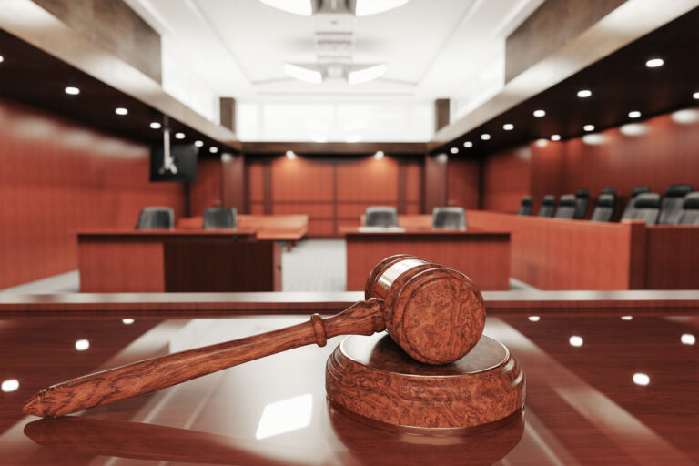 Interior of an empty courtroom with gavel and sounding block on the desk (Getty Images/imaginima)