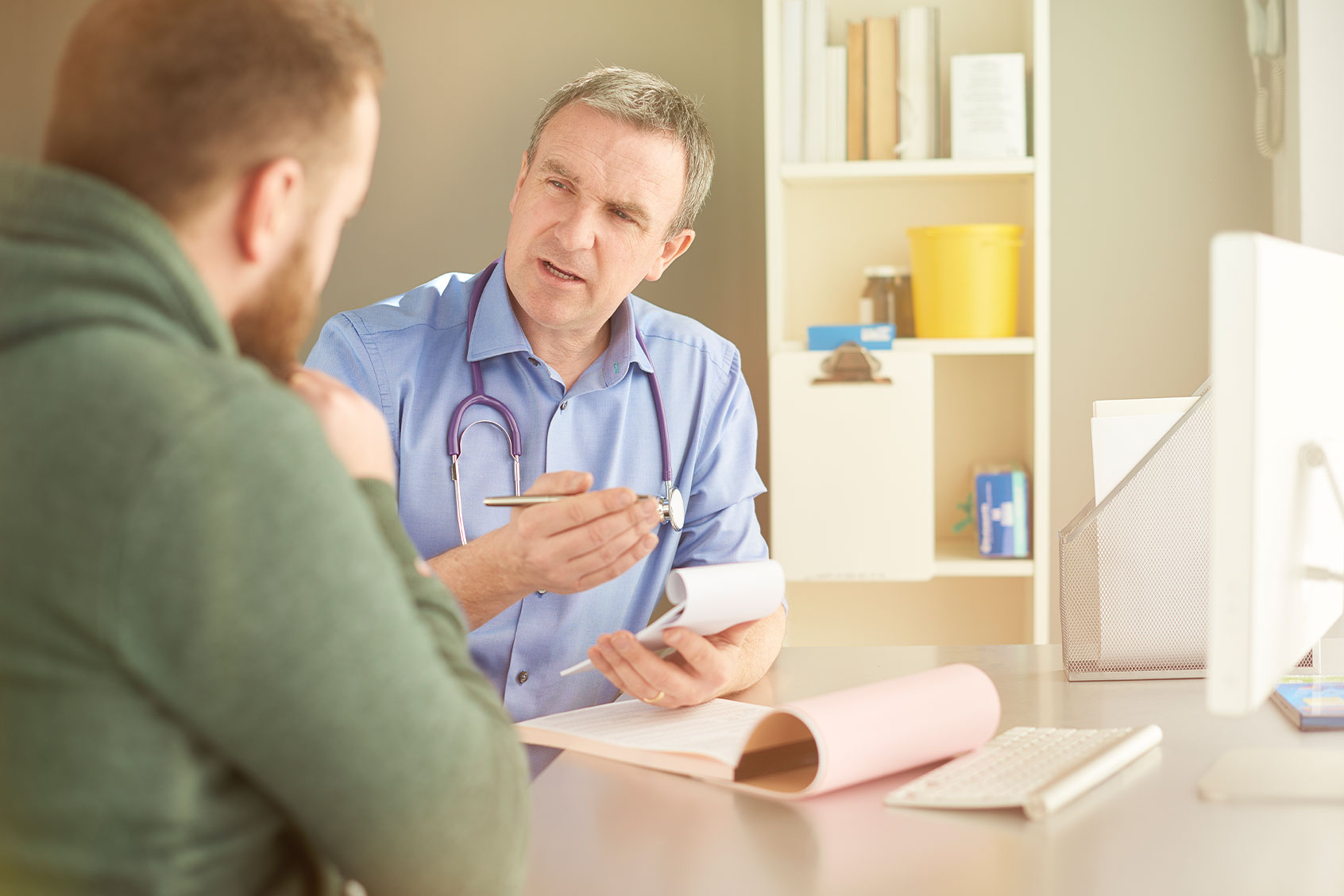 Doctor explains something to his patient whilst writing a prescription (Getty Images/sturti)