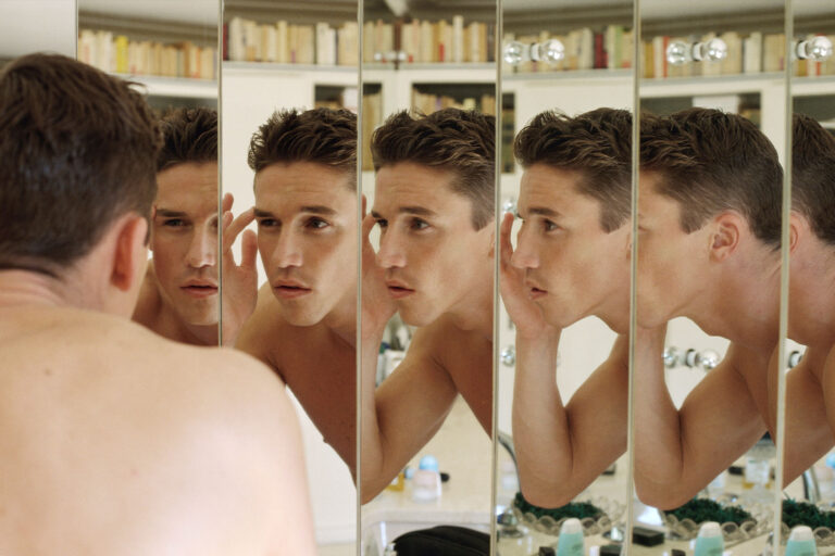 man touching eyebrow, multiple reflections (Getty Images/Vera Atchou)