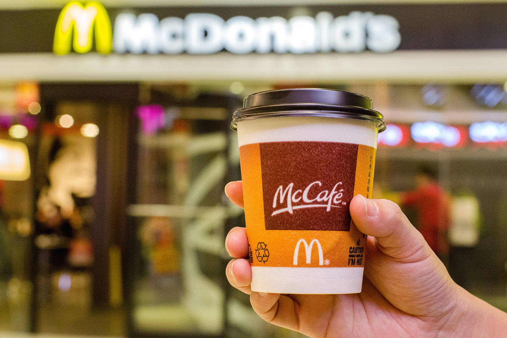 A customer holds a cup of Coffee served by McCafe out of a McDonald's restaurant. ( Zhang Peng/LightRocket via Getty Images)