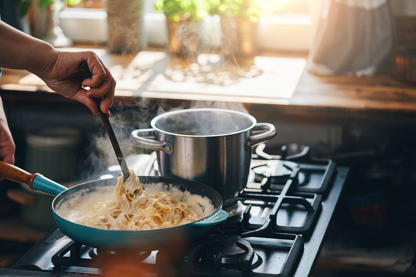 Preparing Fettuccine Pasta Alfredo with Parmesan (Getty Images/GMVozd)