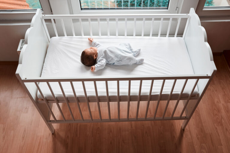 Baby sleeping in their crib (Getty Images/stock_colors)