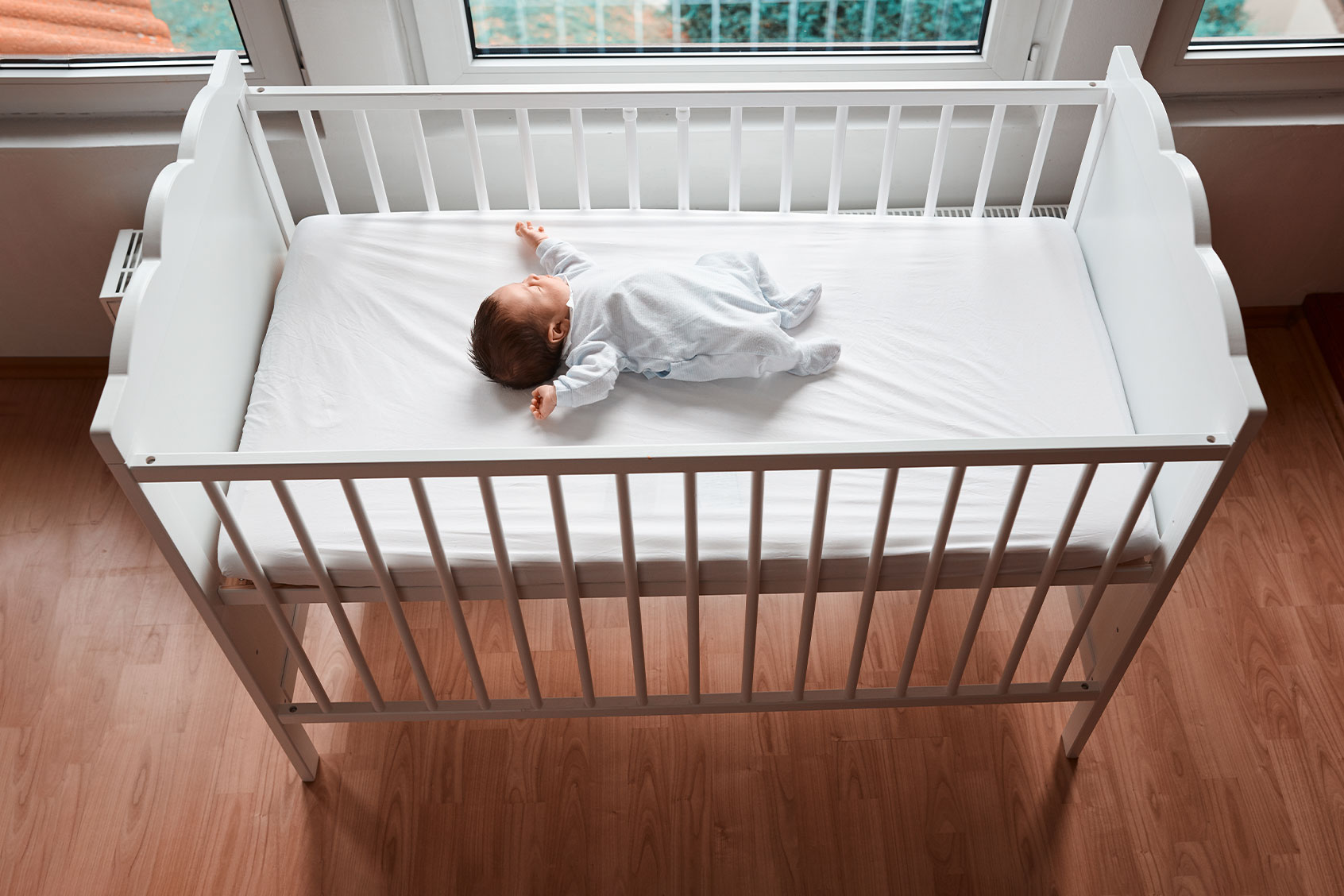 Baby sleeping in their crib (Getty Images/stock_colors)