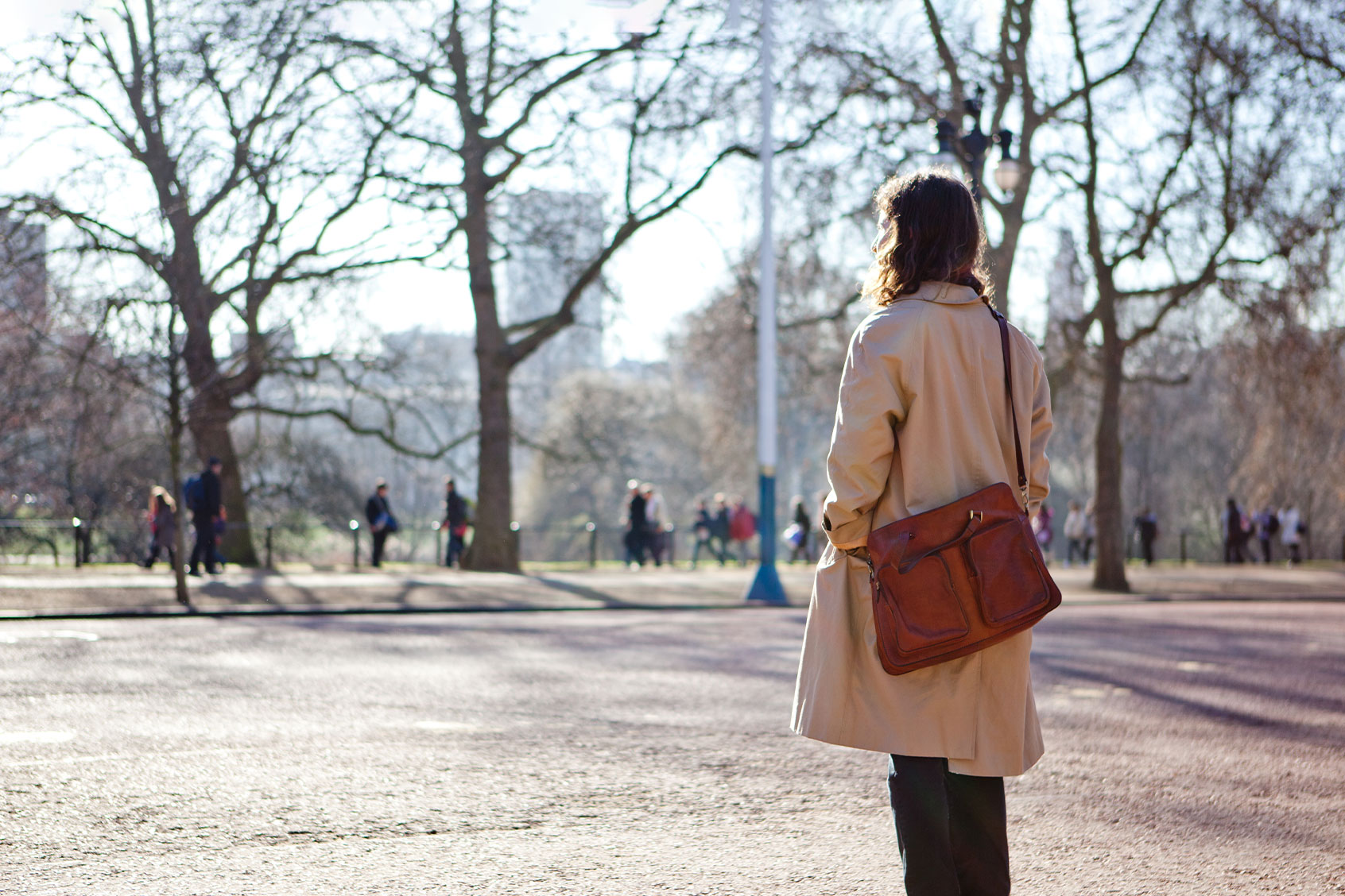Woman in a trench coat looking on at a park (Getty Images/James Whitaker)