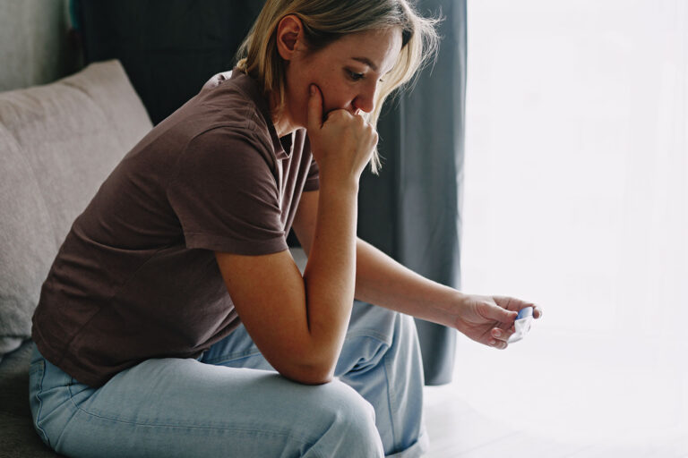 A young woman holding a pregnancy test (Getty Images/Ekaterina Goncharova)
