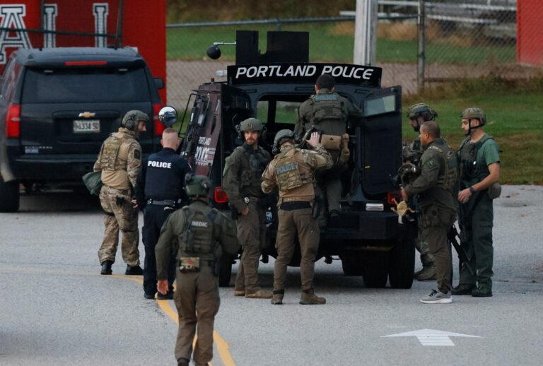 Law enforcement officials load into a tactical vehicle at Lisbon High School at daybreak as a manhunt resumes for the suspect in a mass shooting that took place the day prior. (Jessica Rinaldi/The Boston Globe via Getty Images)