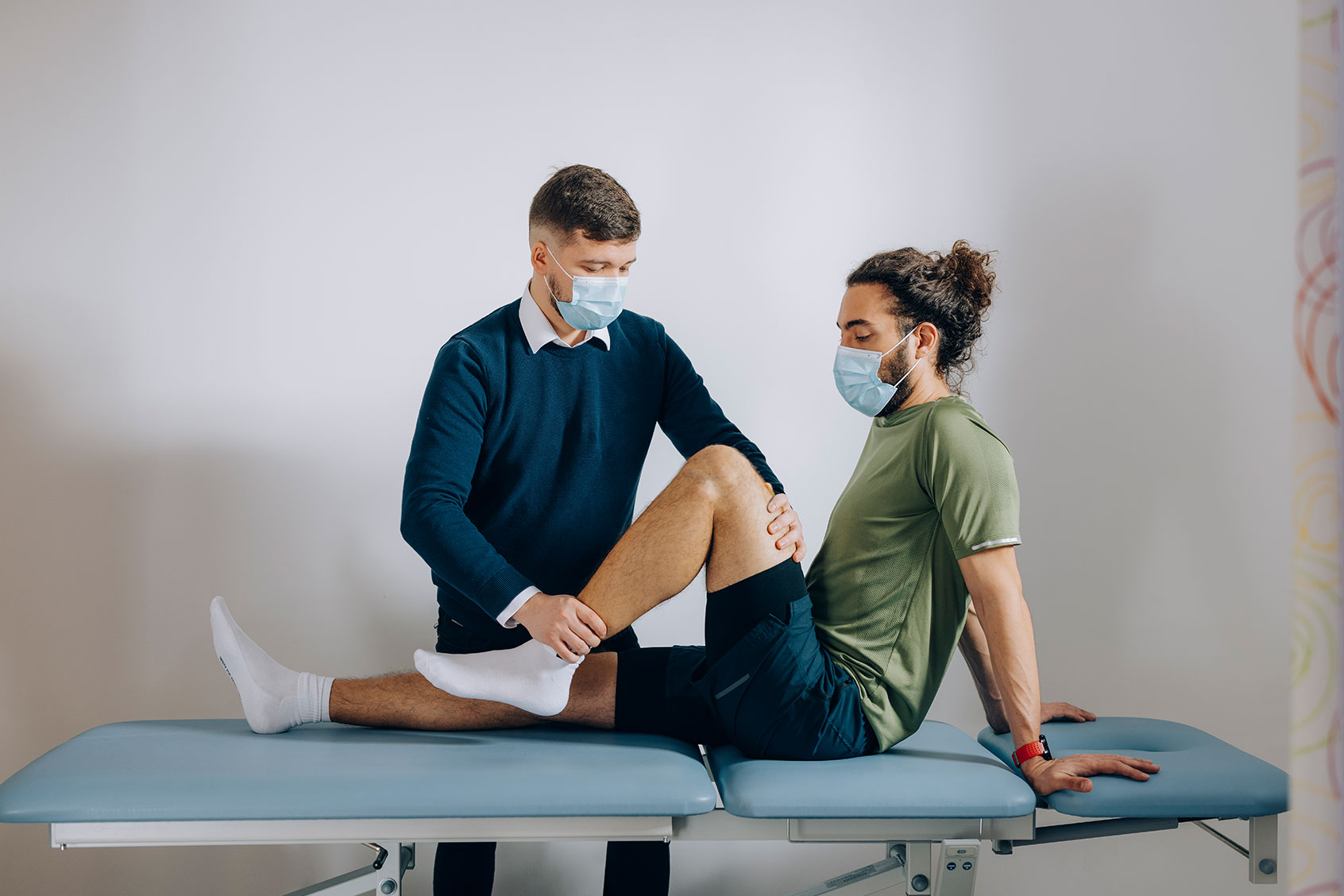 Doctor holding patient leg while he is sitting (Getty Images/miniseries)