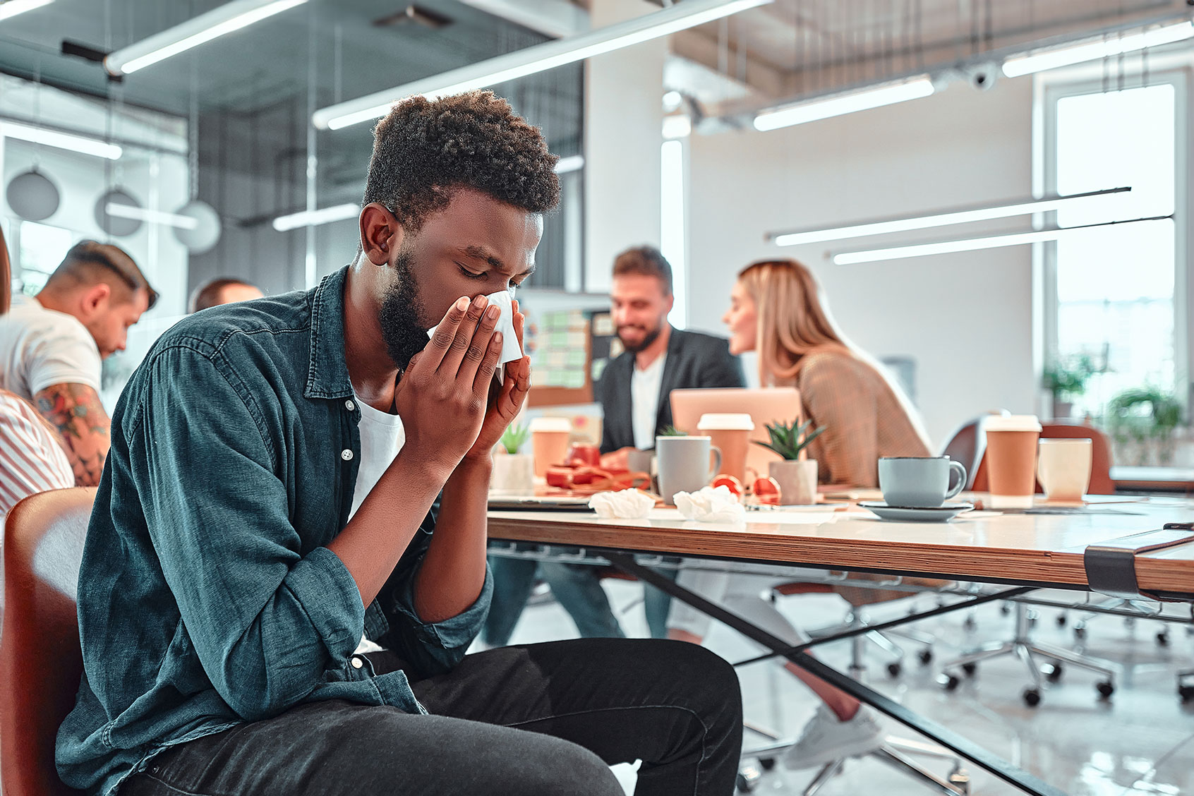 Man ill with flu in office (Getty Images/Harbucks)
