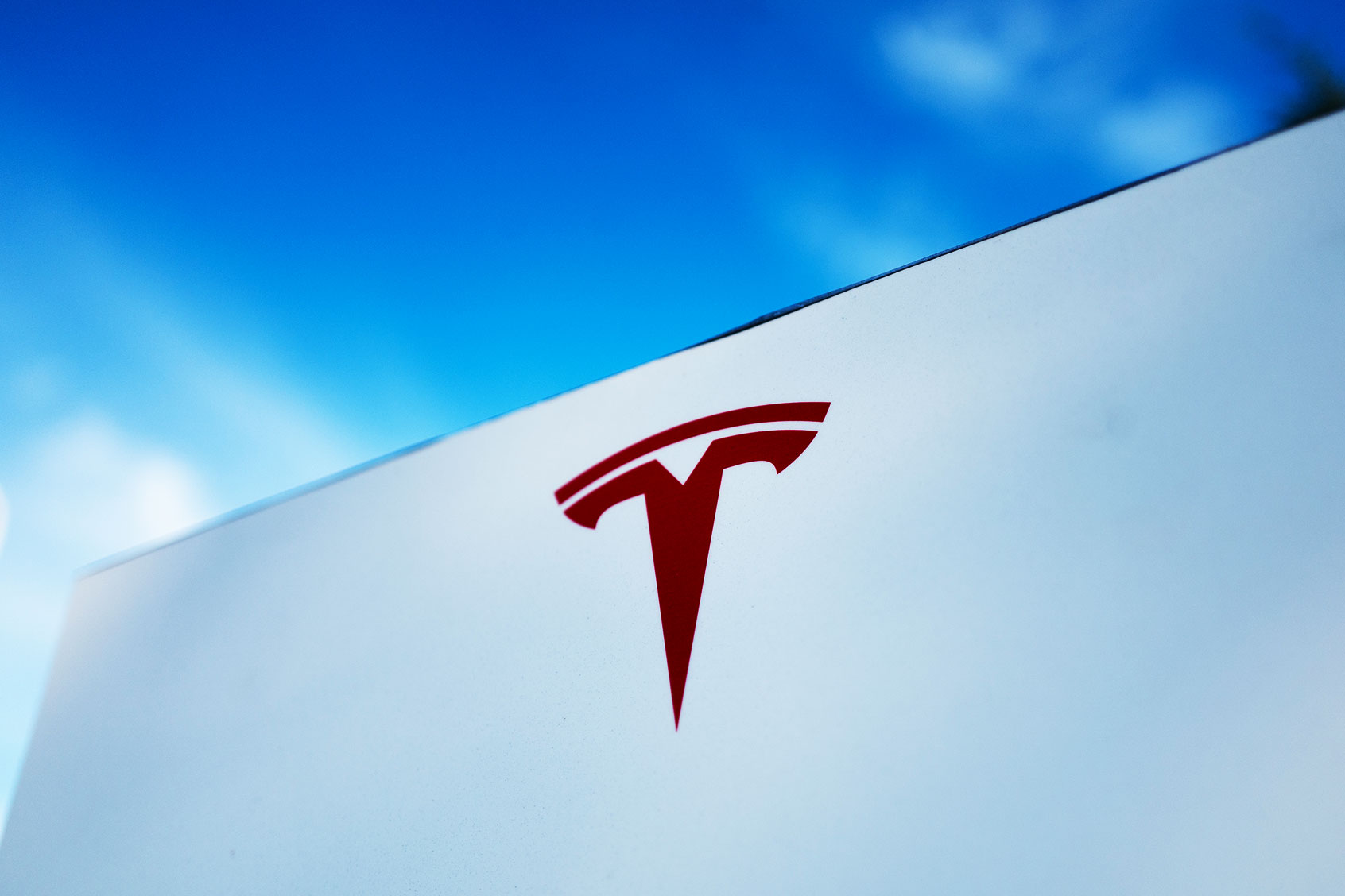 Close-up of Tesla Motors logo against a bright blue sky (Smith Collection/Gado/Getty Images)